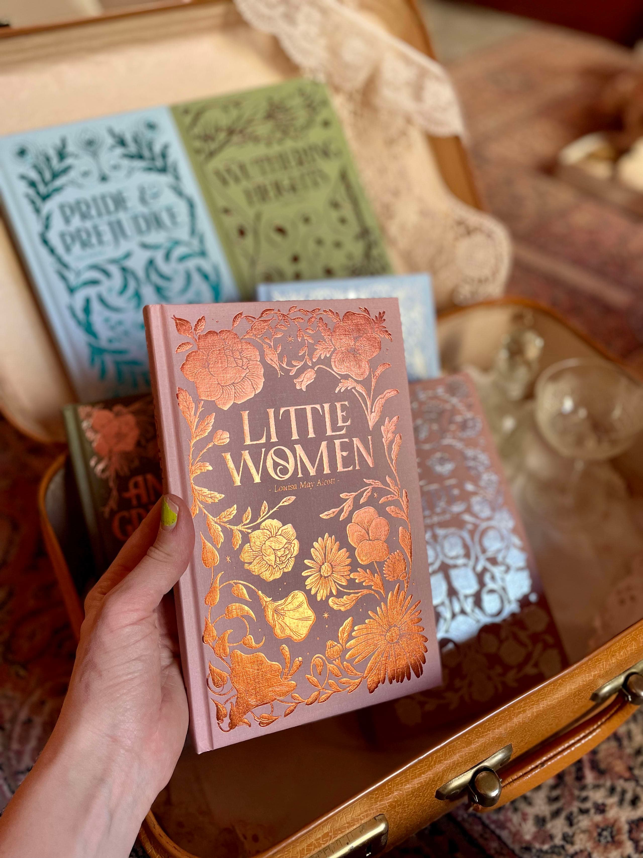 hand holding a copy of Little Women, illustrated cover