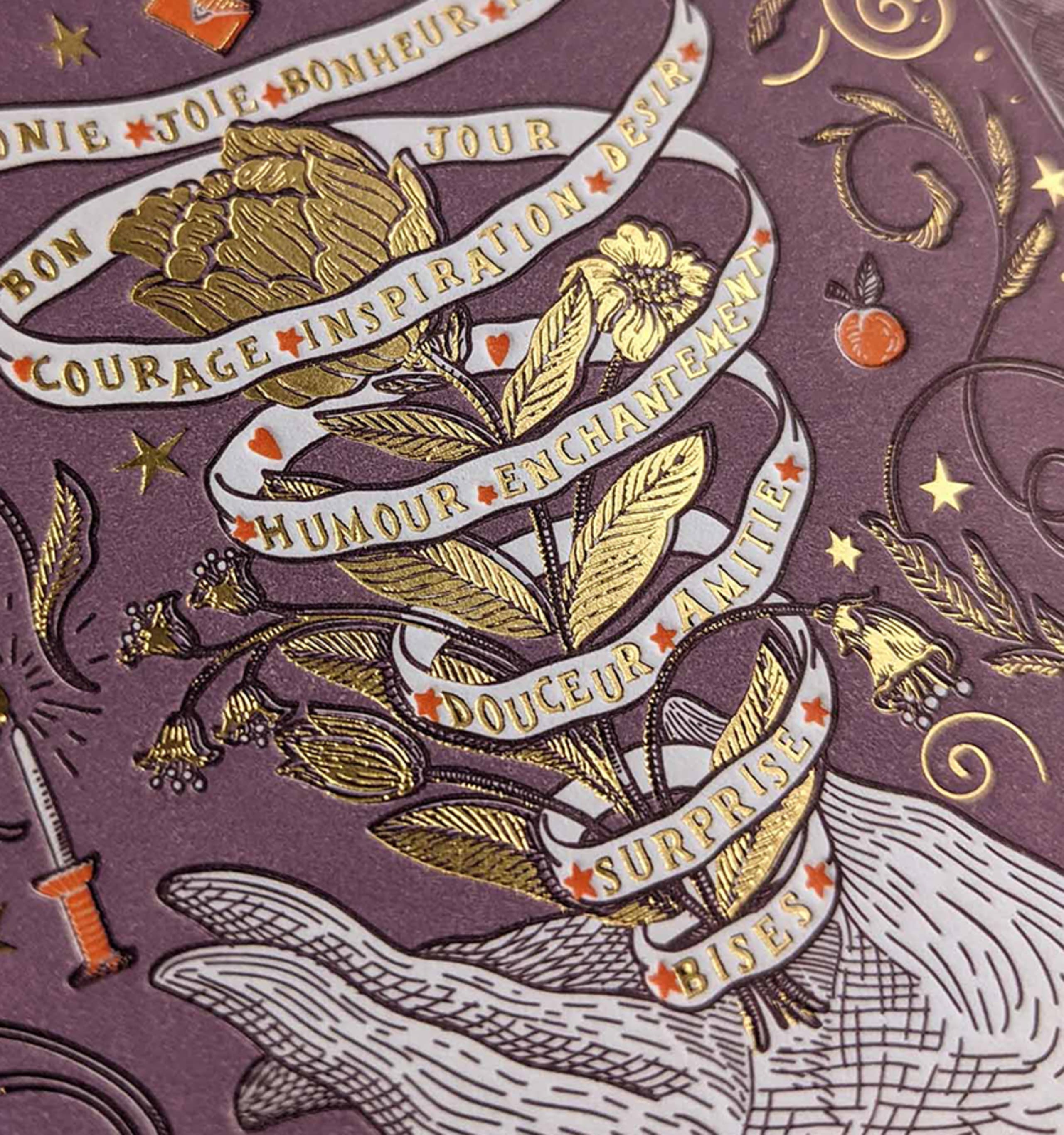 Gold foil botanicals and a spiraling white ribbon on deep aubergine paper, dense with engraved ornament.